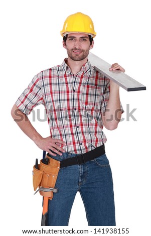 Craftsman with wood plank over his shoulder
