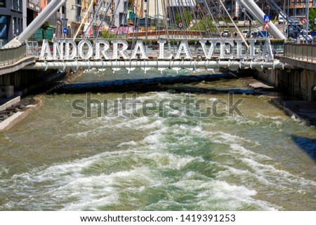 bridge over a mountain river and the inscription Andorra la Vella