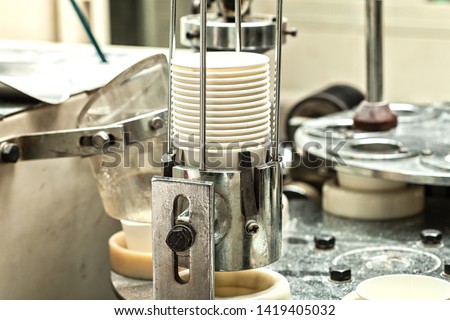 Production of paper cups out of cardboard for coffee on modern equipment.