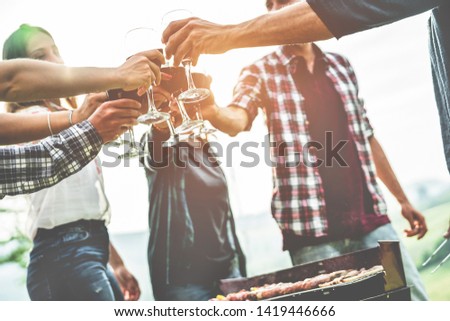 Adult friends cheering with wine at barbecue outdoor - Group of people having fun drinking wine in vineyard at sunset outside - Friendship, summer lifestyle and party concept - Focus on right top hand