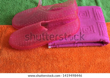 sea shoes for walking on the seashore and protecting against sharp stones and corals against the backdrop of bright beach towels