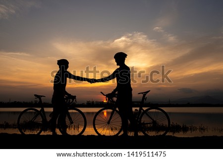 Two cyclists shaking hand after finish ride bicycle together. sportsmanship concept. Royalty-Free Stock Photo #1419511475