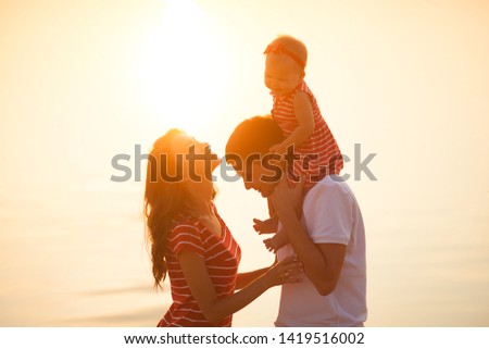 Happy family on the sunset beach. Family walking on water. Vacation background.