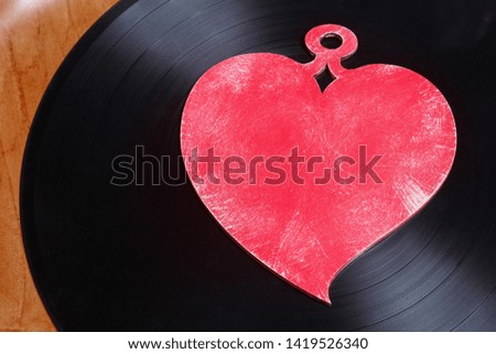 LP vinyl record with red heart. This is nostalgic love song, retro styled. Royalty-Free Stock Photo #1419526340