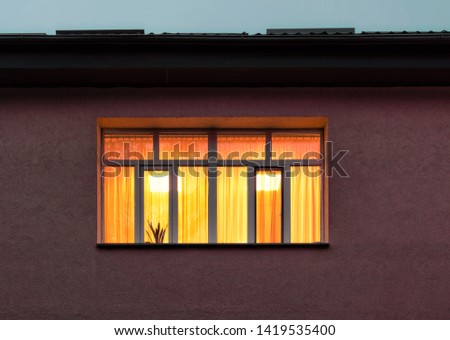 Yellow light in window inside Royalty-Free Stock Photo #1419535400
