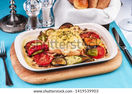 
Mediterranean dish, Georgian recipe. Baked chicken steak with lemon, vegetables, pepper, zucchini, eggplants and grilled tomatoes with spices