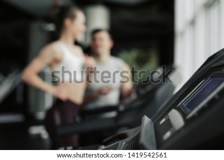 Side view of smiling sporty woman training on race track with instructions of coach. Keeping healthy lifestyle, doing cardio exercises. Girl having pretty face.
