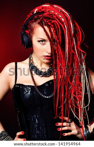 Expressive girl in headphones with great red dreadlocks.