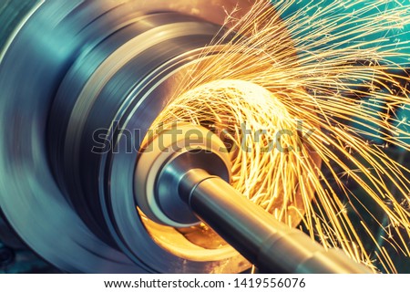 Internal grinding of a cylindrical part with an abrasive wheel on a machine, sparks fly in different directions. Metal machining. Royalty-Free Stock Photo #1419556076