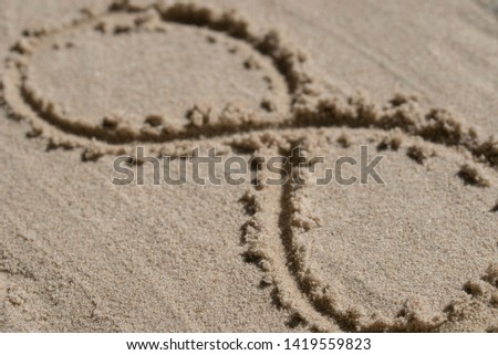 infinity symbol - drawing on sand background