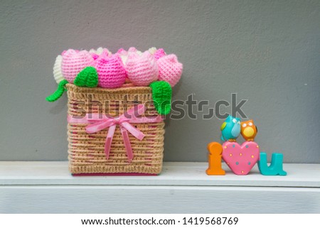 knit blankets, roses knit blanket.Basket with pink roses made from knitting near model i love uand bird cartoon on gray background.
