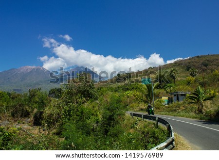 A Landscape of Lewotobi mountain, a twins volcano, street path and motorcycle from Larantuka, East Nusa Tenggara, Indonesia