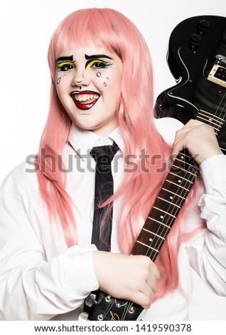 young girl with professional comic pop art make-up holding electric guitar. Funny cartoon or comic strip make-up