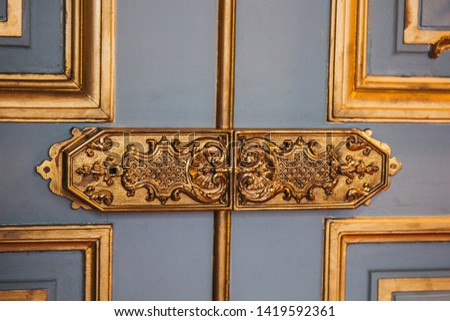 vintage door hinges painted patterns covered with gold leaf close-up. luxury fittings in the interior.