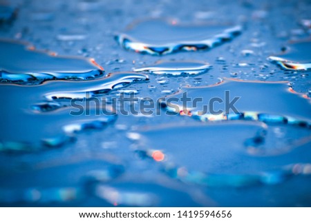 blue drops of water on the glass in the sun