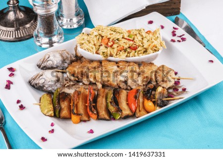 Mediterranean dish, Georgian recipe. Baked chicken skewers with lemon, vegetables, pepper, zucchini, eggplants and grilled tomatoes with spices, and steamed rice