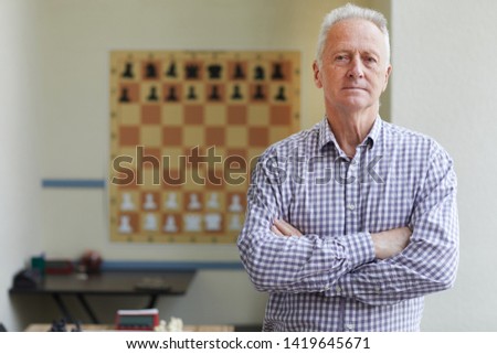 Famous aged male experienced grandmaster posing for pictures after winning chess tournament