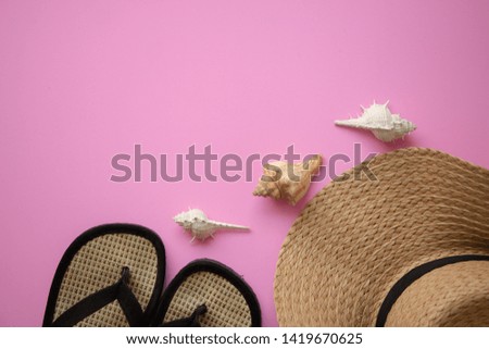 Beach accessories straw hat with notebook,sea shell on pastel pink background,Summer holiday and vacation concept.Copy space top view, flat lay.
