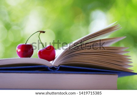 Two ripe cherries in open book