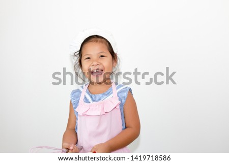 Little kid girl holding bakery equipment she is happy.