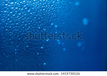 Water Drops on a Glass, Blue Surface. Science and Cosmetics Background. Concept of Hydration. Full Frame Shot. High Resolution Photography.
