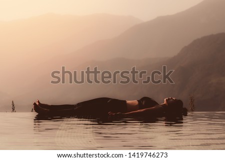 Morning light with Beautiful Attractive Asian woman practice yoga Dead Body or Savasana on the pool above the Mountain peak in front of beautiful nature views in SAPA vietnam,so comfortable,Warm Tone Royalty-Free Stock Photo #1419746273
