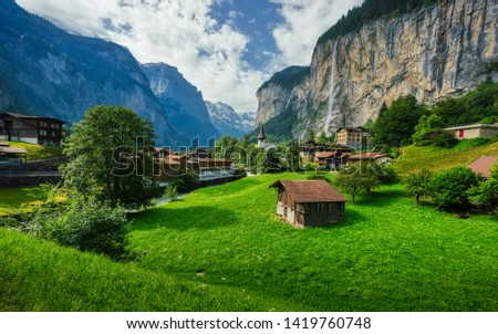Amazing view of famous Lauterbrunnen town in Swiss Alps valley with beautiful Staubbach waterfalls in the background, Switzerland.