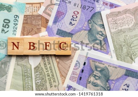 NBFC in wooden block letters on indian currency Royalty-Free Stock Photo #1419761318