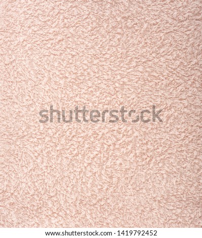The texture of the fabric is light pink terry towel. Terry cloth as a background. Close up