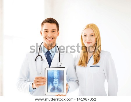 bright picture of two doctors showing x-ray on tablet pc