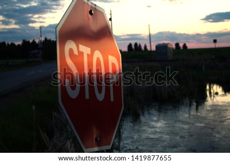 stop sign by a cold pond