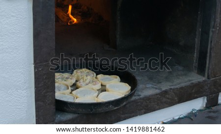 Process of cooking hot mini pies with chicken and cheese at street food festival. Outdoor cooking, service, gastronomy and takeaway food concept