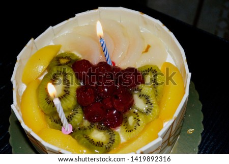 candles on fruity wet cake