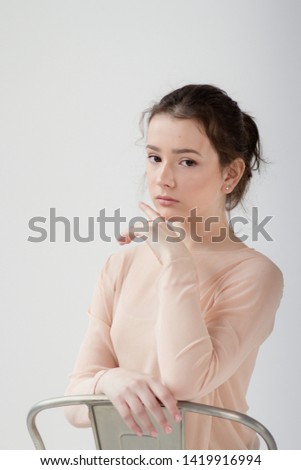 
Portrait of a girl dancer on a white background in beige tights with a place for text