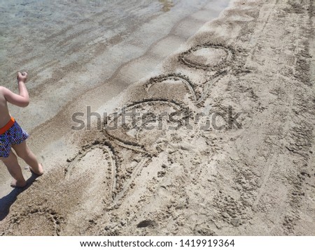 2020 sign on the beach and child
