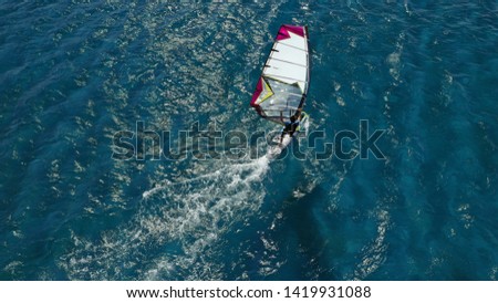Aerial photo of wind surfer cruising in high speed in tropical exotic bay with deep blue sea