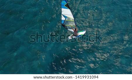 Aerial photo of wind surfer cruising in high speed in tropical exotic bay with deep blue sea