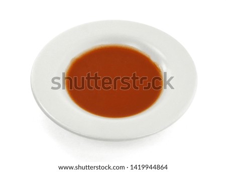 Closeup red ketchup tomato soup in a plate isolated on white background. 
