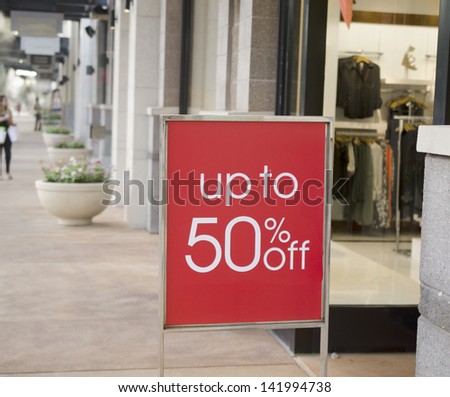Sale sign outside fashion retail store in shopping mall