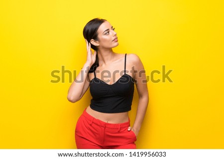 Young woman over isolated yellow background thinking an idea