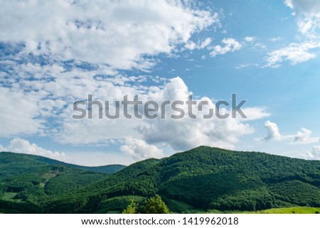 The green background of the mountains and the cloudy sky. Panorama of the mountains.