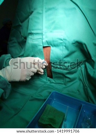 Anaesthetist performing Spinal Anaesthesia procedure under aseptic precaution in operation theatre.