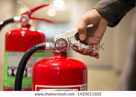Fire extinguishers,Close-up  engineers hands are squeezing the Handle on the fire extinguisher.