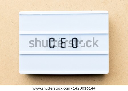 White lightbox with word CEO (abbreviation of Chief Executive Officer) on wood background