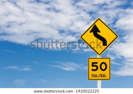 Warning traffic sign of curve road and limit speed on blue sky background