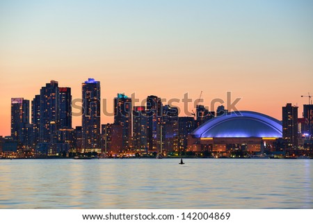 Toronto sunset silhouette at dusk over lake with urban architecture. Royalty-Free Stock Photo #142004869