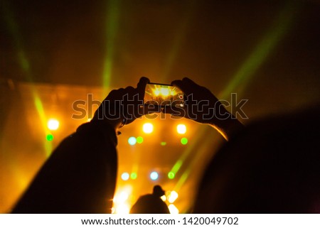 Shooting a concert on a smartphone. The image on the display of the gadget. Music band on stage. Performance of the singer. Music Festival. Live performance.