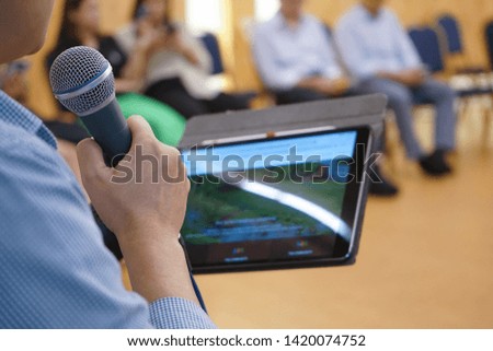 Electronic device on Asian Hand play social media in the meeting room with blur people behind
