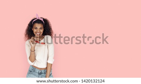 Happy smiling fashion young african teen girl black woman holding stylish glasses looking at camera isolated on pink summer studio background, banner for website design, portrait, copy space