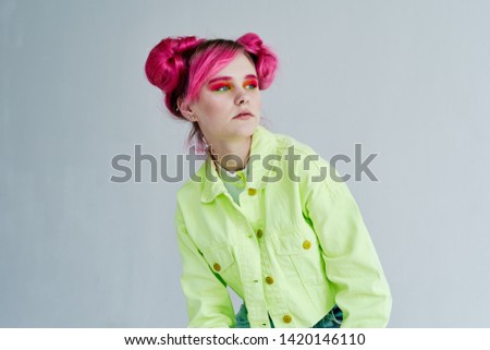 serious woman with pink hair on gray background